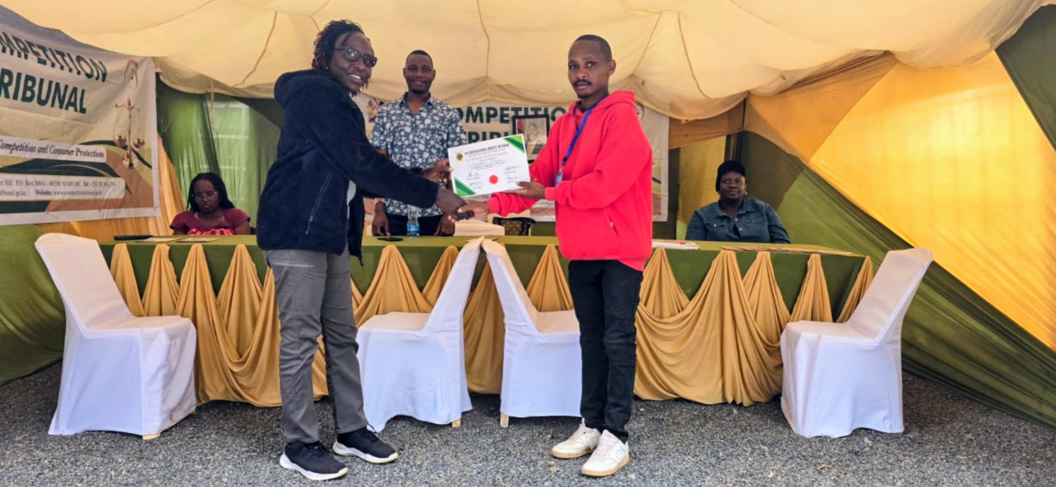 Mrs Joyce M,ibari,receiving a certificate of participation on behalf of the tribunal from a representative of the A.S.K